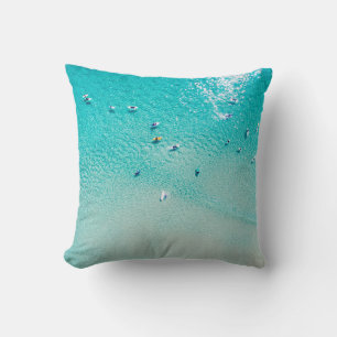 An aerial view of surfers waiting for a wave in th throw pillow