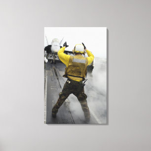 An aircraft director signals a F/A-18C Hornet Canvas Print