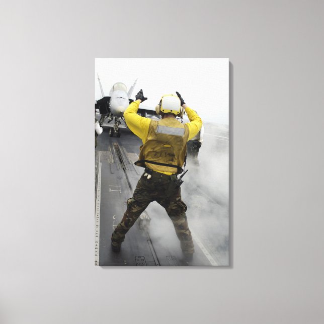 An aircraft director signals a F/A-18C Hornet Canvas Print (Front)
