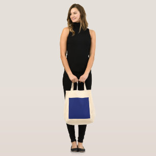an airplane flying in the sky with a blue backgrou tote bag