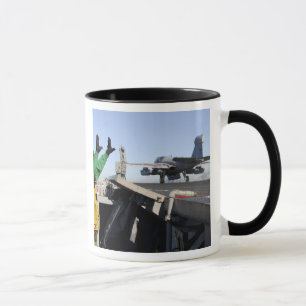 An EA-6B Prowler launches from the flight deck Mug