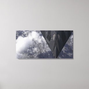An F-117A Nighthawk flies high over the mountai Canvas Print