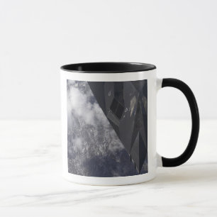 An F-117A Nighthawk flies high over the mountai Mug