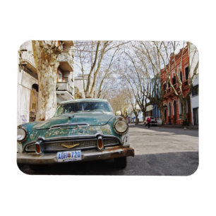 An old car rusty and flaky colour parked in the magnet