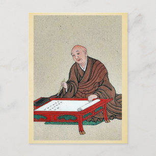 An old man seated a low table, writing postcard