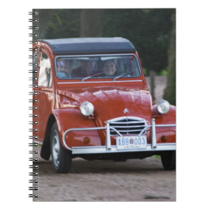 An old red Citroen 2CV car with a smiling woman Notebook