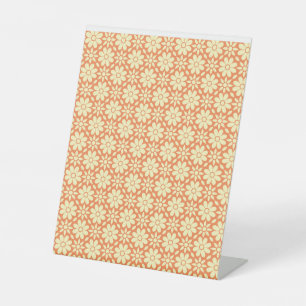 an orange and white background with a pattern pedestal sign