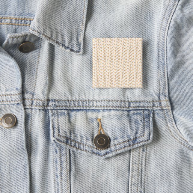 an orange and white background with swirls 2 inch square button (In Situ)