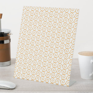 an orange and white background with swirls pedestal sign