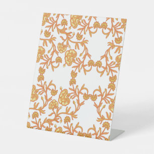 an orange and white wallpaper with a floral design pedestal sign