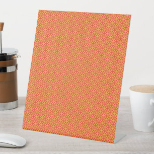 an orange and yellow background with small squares pedestal sign