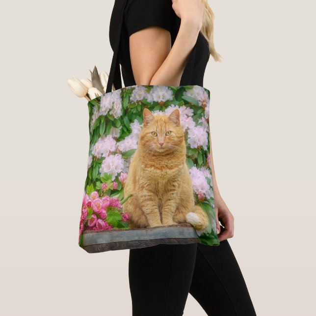 An Orange Cat in a Garden with Pink Spring Flowers Tote Bag (Close Up)