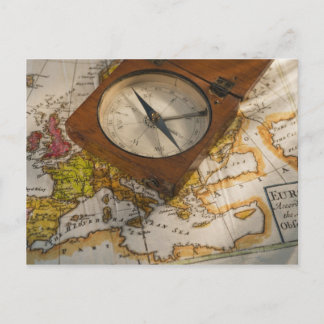 Antique compass on map postcard