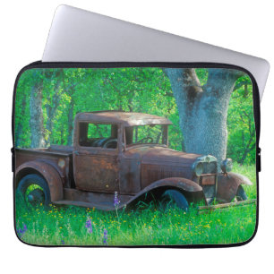 Antique rusted truck in a meadow laptop sleeve