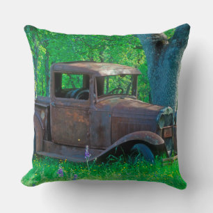 Antique rusted truck in a meadow throw pillow