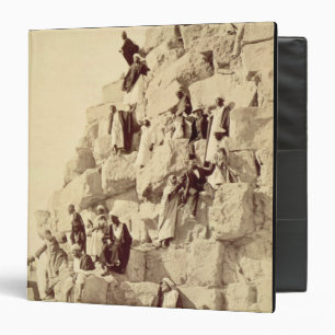 Arabs assisting tourists to climb the pyramids at binder