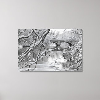 Arch Bridge over Frozen River in Winter Canvas Print