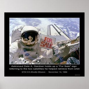 Astronaut Dale A. Gardner holds up "For Sale" sign