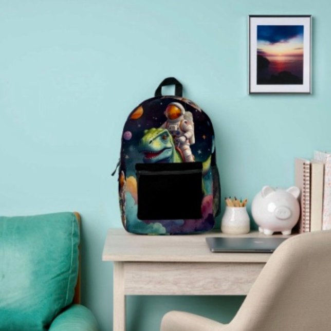 Astronaut on Dino in Space  Printed Backpack (Backpack – D: 17"x12.5"x5" Two-chamber design with laptop storage pouch. Mesh side pocket.
 
)