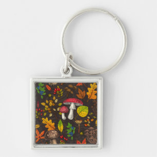 Autumn mushrooms, leaves, nuts and berries on dark keychain