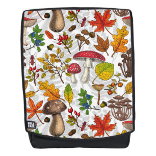 Autumn mushrooms, leaves, nuts and berries on whit backpack