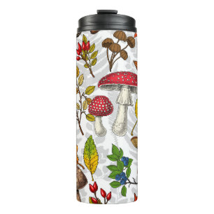 Autumn mushrooms, leaves, nuts and berries on whit thermal tumbler