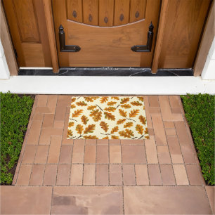 Autumnal oak leaves on off white doormat