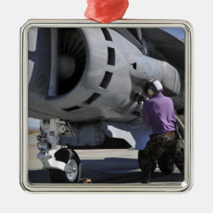 Aviation fuel technician attaches a fuel line metal ornament
