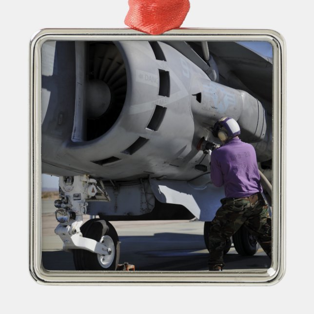 Aviation fuel technician attaches a fuel line metal ornament (Front)