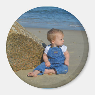 Baby by the ocean pondering. magnet