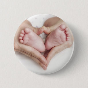 Baby feet in mother hands 2 inch round button