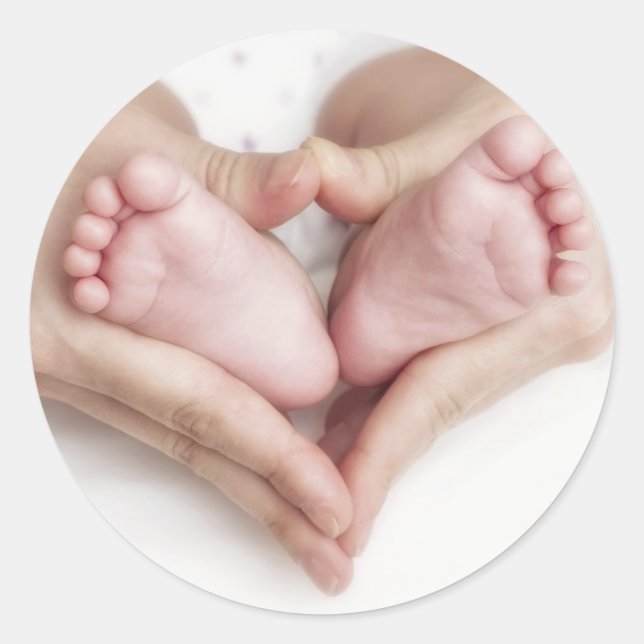 Baby feet in mother hands classic round sticker (Front)
