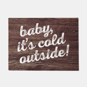 baby, it's cold outside! on dark wood background doormat