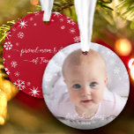 Baby Photo First Christmas Snowflakes New Parents Ornament<br><div class="desc">“First Christmas.” A playful visual of white snowflakes and handwritten script typography with customized year, overlaying the photo of your choice, help you usher in Christmas and New Year. On the back, additional white snowflakes and handwritten typography with “proud mom & dad of baby’s name” overlay a red background. Feel...</div>