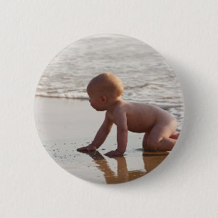 Baby playing in the sand on the beach 2 inch round button