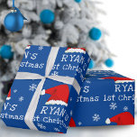 Baby`s First Christmas Blue Santa Hat Snowflake Wrapping Paper<br><div class="desc">Baby`s First Christmas Blue Santa Hat Snowflake Wrapping Paper. Cute baby first Christmas design with a Santa hat,  snowflakes and a baby name in a white script on a blue background - personalize with your baby`s name.</div>