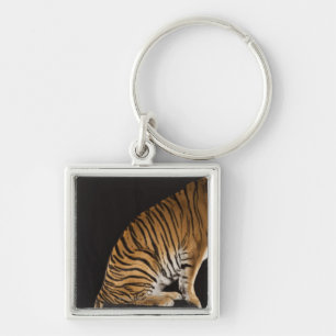 Back end of tiger sitting on platform keychain