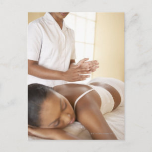 Back massage. Woman receiving a back massage by Postcard