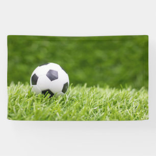 Banderoles La balle de football est sur l'herbe verte arrière