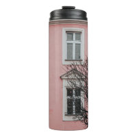BARE TREE IN FRONT OF PINK BUILDING
