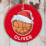 Basketball Ball Red Santa Hat Christmas Kid Name  Ceramic Ornament<br><div class="desc">Basketball Ball Red Santa Hat Christmas Kid Name Ceramic Ornament. Fun basketball ball with a red Santa hat on a red background with white snowflakes. The ornament has a name template - personalize it with your name.</div>