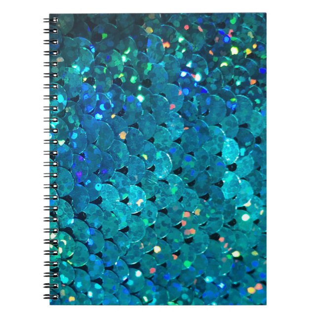 Beautiful and colourful sequins sparkling under th notebook (Front)