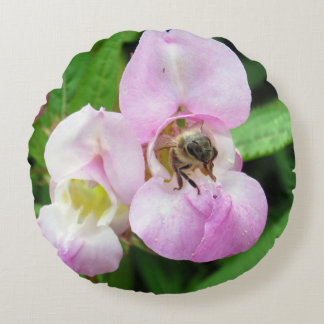 Bee emerging from a sweet pea flower round pillow