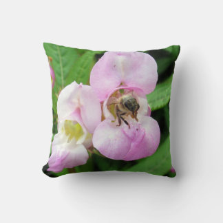 Bee emerging from a sweet pea flower throw pillow