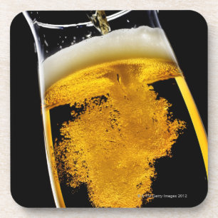 Beer been poured into glass, studio shot coaster