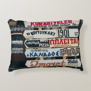 BEIGE RED AND BROWN SIGNAGES ON BEIGE STAND AT DAY ACCENT PILLOW