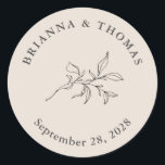 Beige Simple Botanical Wedding Classic Round Sticker<br><div class="desc">Simple and elegant with minimalist appeal, this wedding favour sticker has an autumn beige background with elegant charcoal grey text. The text template includes the Bride and Groom's names and their wedding date. A simple botanical leafy branch adds a floral element in the centre of the design. This sticker is...</div>