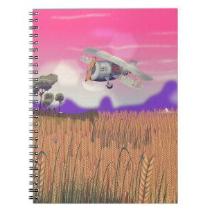 Bi-Plane Flying over crops under setting sun Notebook