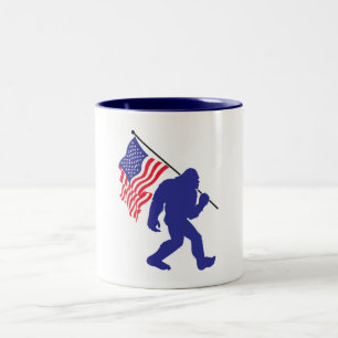 Bigfoot carrying the American Flag Two-Tone Coffee Mug