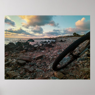Bike parked at rocky beach poster